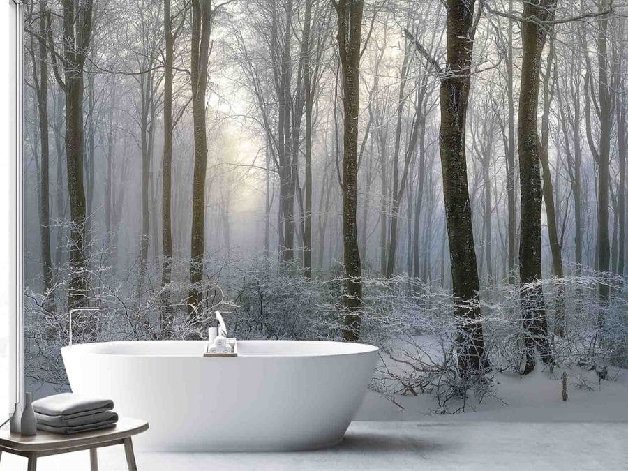 Dark Winter Forest Wallpaper, as seen on the wall of this bathroom, is a photo mural of icy trees over a snow covered forest floor from About Murals.