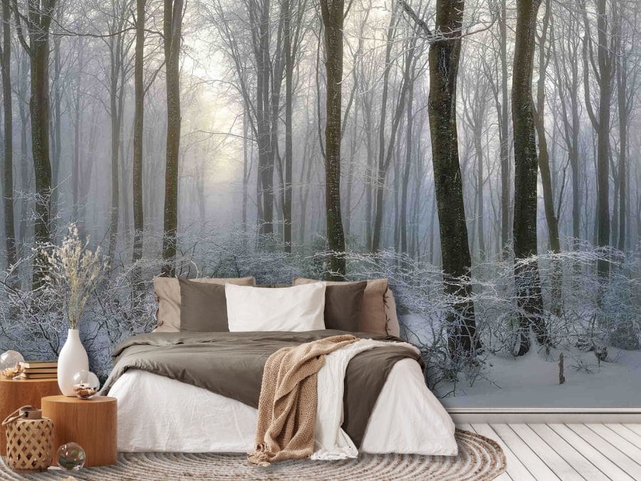Dark Winter Forest Wallpaper, as seen on the wall of this bedroom, is a photo mural of tall black trees and foliage covered in ice hovering over a carpet of snow in the gray woods from About Murals.
