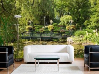 Water Garden Wallpaper, as seen on the wall of this living room, is a photo mural of a bridge over a pond surrounded by trees, plants and flowers from About Murals.
