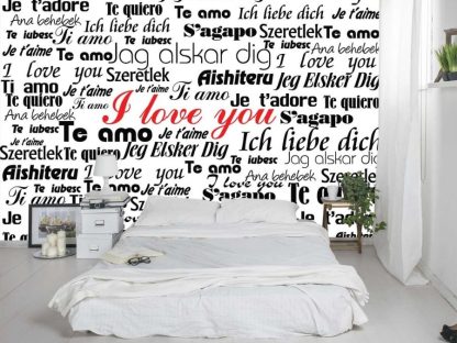 Love Wallpaper, as seen on the wall of this bedroom, is a mural with the words, "I love you" written in red and black in different languages from About Murals.