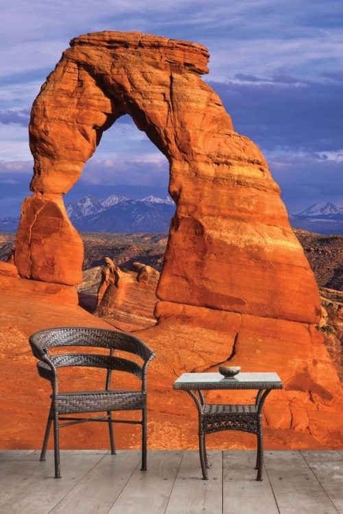 Arches National Park Wallpaper, as seen on the wall of this sitting room, is a photo mural of a red rock formation overlooking mountains in Utah from About Murals.