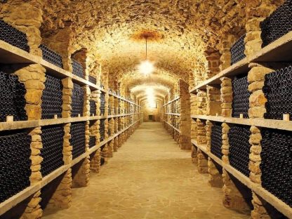Cellar Wallpaper is a photo wall mural of a stone wine cellar lined with hundreds of wine bottles from About Murals.