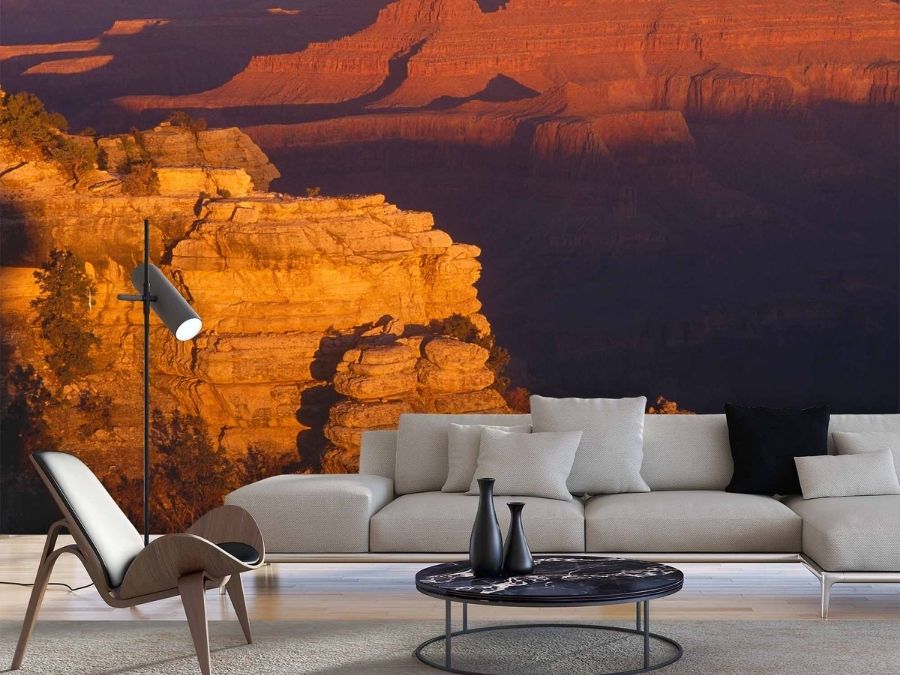 Grand Canyon Wallpaper, as seen on the wall of this living room, is a photo mural of the beautiful rock formations in a sunrise from About Murals.