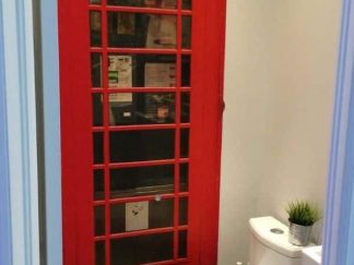 Phone Booth Wallpaper, as seen on the wall of this restroom, is a photo mural of a vintage red English telephone booth from About Murals.