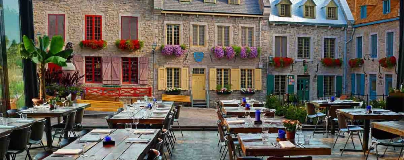 Quebec City Wallpaper, as seen on the wall of this dining room, is a photo mural of stone buildings at the Place Royale from About Murals.