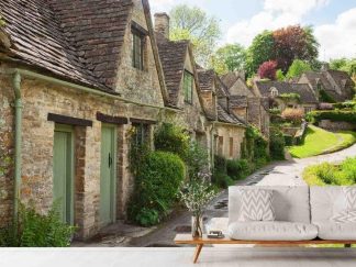 English Cottage Wallpaper, as seen on the wall of this living room, is a photo mural of the famous stone cottages on Arlington Row in Bibury, Cotswolds, England from About Murals.