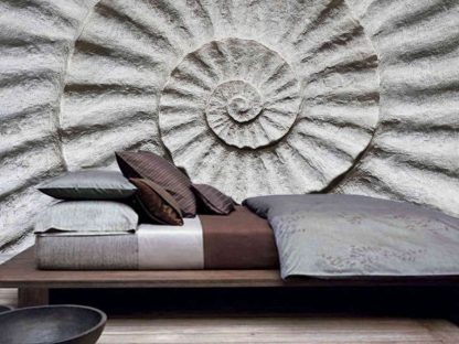 Fossil Wallpaper, as seen on the wall of this bedroom, is a photo mural of a monochrome shell fossil, called an ammonite, in a spiral pattern from About Murals.