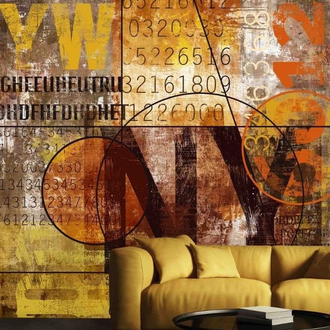 NYC Graffiti Wallpaper, as seen on the wall of this living room, is a mural with the letters "NY" on an industrial background from About Murals.