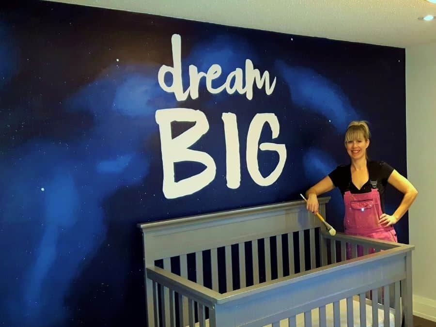 A painted mural in Ancaster, ON of the words "Dream Big" over an outer space sky background created by muralist Adrienne of About Murals.