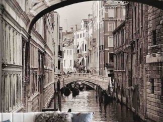 Venice Wallpaper, as seen on the wall of this living room, is a photo mural of a gondolier rowing a gondola boat on a canal under the Bridge of Sighs from About Murals.