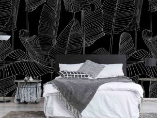 Black and White Banana Leaf Wallpaper, as seen on the wall of this bedroom, is a wall mural with tall white leaf patterns on a black background from About Murals.