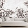 Brown Tropical Wallpaper, as seen on the wall of this living room, is a wall mural of palm leaves on a beige textured background from About Murals.