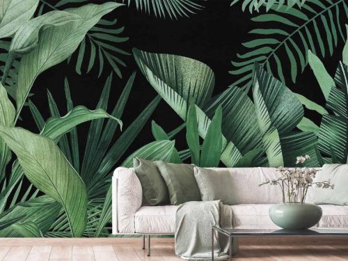 Jungle Leaf Wallpaper, as seen on the wall of this living room, is a wall mural with green banana leaf and palm leaf patterns on a black background from About Murals.