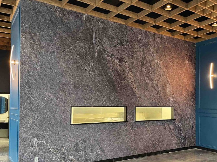Stone Slab Wallpaper, as seen on the wall of this room, is a realistic photo mural of a grey granite wall with a natural aesthetic from About Murals.
