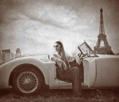 Vintage Paris Wallpaper is a brown wall mural of a French model sitting in an Austin Healy 3000 near the Eiffel Tower from About Murals.