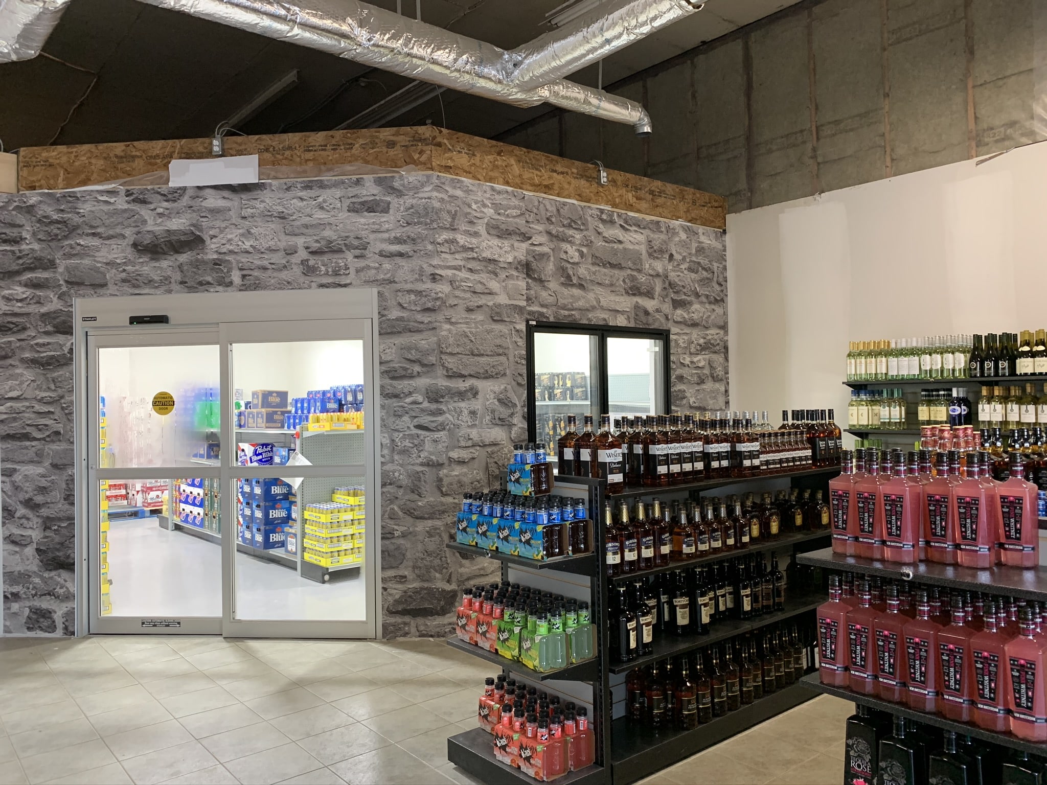 Liquor Store Wallpaper, as seen on the wall of this LCBO Convenience outlet, is a photo mural of a realistic stone wall from About Murals.