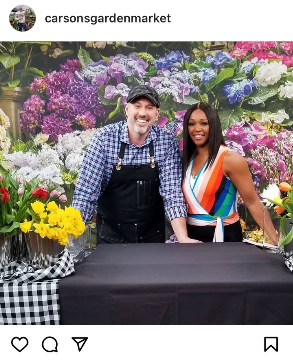 A photo of non-toxic wallpaper features Carson Arthur and Tracy Moore in front of a floral wallpaper on set at Cityline, supplied and installed by About Murals.