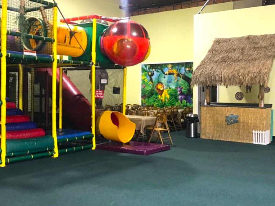 Indoor playground design ideas using kids wallpaper murals from About Murals in an animal theme with a tiki bar and climbing structure.