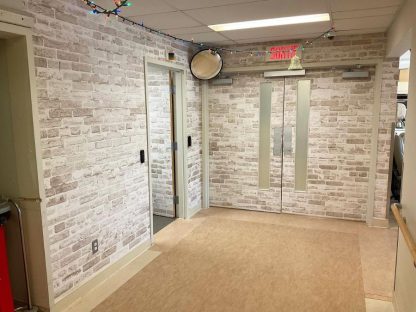 Exit diversion door wraps, like this hidden door wallpaper that looks like a brick wall, helps camouflage doors to keep dementia residents safely inside their long term care facility. Sold by About Murals.